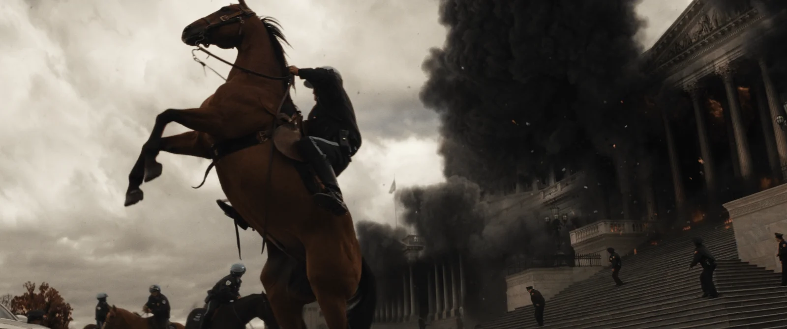 Um cavalo da polícia se ergue diante do Capitólio coberto por fumaça.